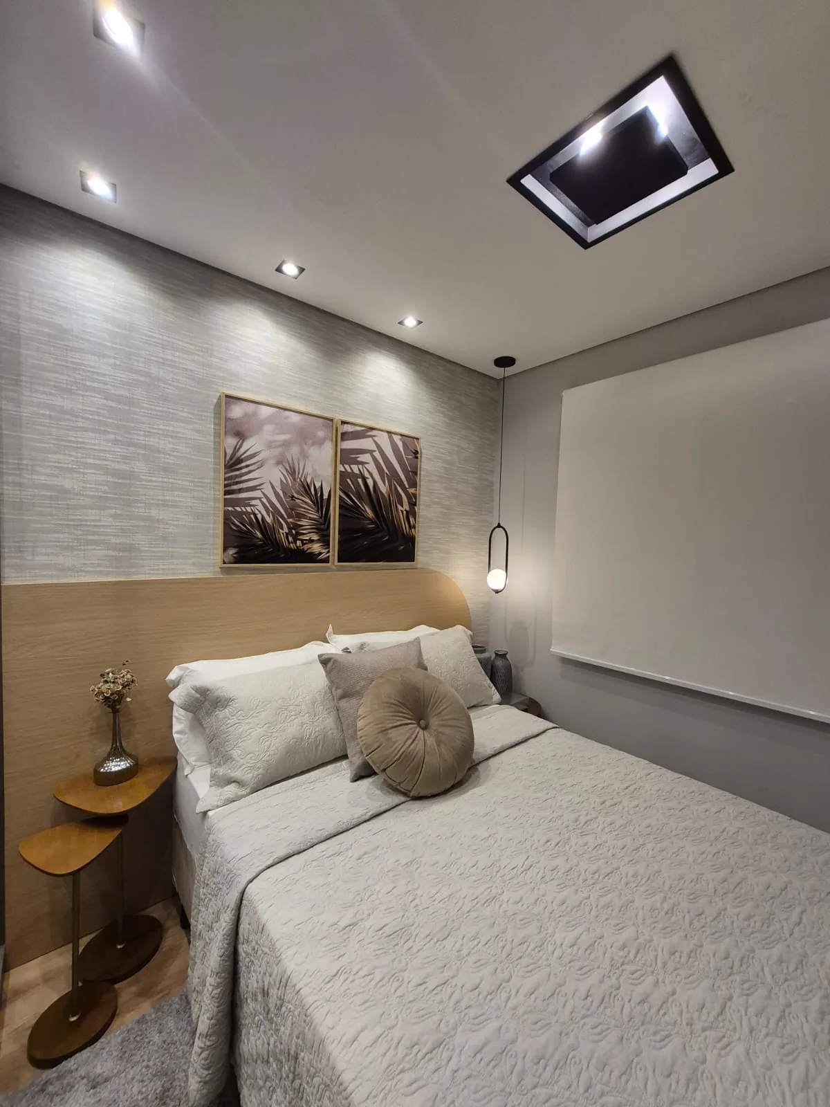 Quarto moderno com papel de parede texturizado e persiana rolô